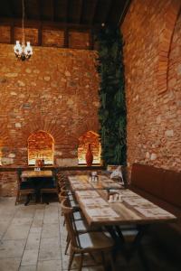 a row of tables in a room with a brick wall at Fibar Hotel Zincirlihan in Aydın