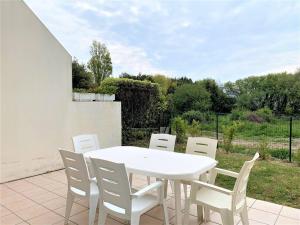 a white table and chairs on a patio at Villa Quiberon, 3 pièces, 6 personnes - FR-1-478-30 in Quiberon