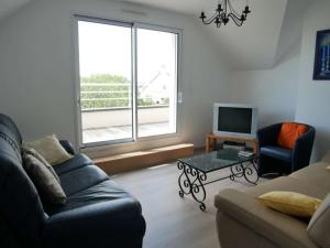 ein Wohnzimmer mit einem Sofa, einem Tisch und einem TV in der Unterkunft Villa Belz, 5 pièces, 8 personnes - FR-1-479-22 in Belz