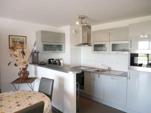 uma cozinha com armários brancos e uma bancada em Appartement Étel, 2 pièces, 4 personnes - FR-1-479-68 em Étel