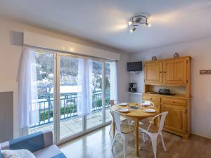 a kitchen and dining room with a table and a balcony at Appartement Cauterets, 2 pièces, 4 personnes - FR-1-401-135 in Cauterets
