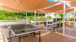 a ping pong table under a tent with tables and chairs at Casa rural cerca de Aracena Castillo de las Guardas by Ruralidays in Seville