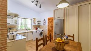 una cocina con una mesa con una cesta de fruta. en Casa rural cerca de Aracena Castillo de las Guardas by Ruralidays, en Sevilla