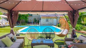 une terrasse avec des chaises et une balançoire en face d'une piscine dans l'établissement Casa rural cerca de Aracena Castillo de las Guardas by Ruralidays, à Séville