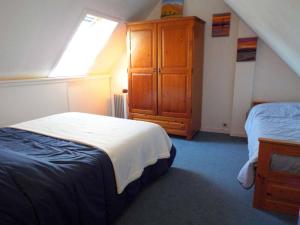 a bedroom with two beds and a wooden cabinet at Appartement Carnac, 3 pièces, 5 personnes - FR-1-477-51 in Carnac
