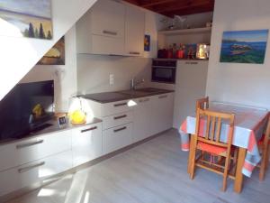 a kitchen with white cabinets and a table and a chair at Appartement Carnac, 3 pièces, 5 personnes - FR-1-477-51 in Carnac