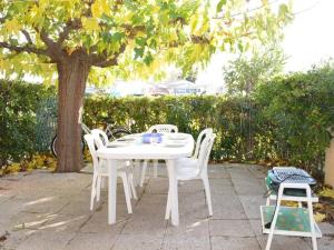 a white table and chairs under a tree at Maison Saint-Cyprien, 3 pièces, 8 personnes - FR-1-225D-616 in Saint-Cyprien-Plage