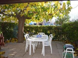 a white table and chairs under a tree at Maison Saint-Cyprien, 3 pièces, 8 personnes - FR-1-225D-616 in Saint Cyprien Plage