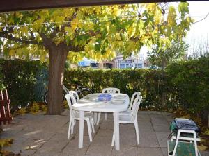a white table and chairs under a tree at Maison Saint-Cyprien, 3 pièces, 8 personnes - FR-1-225D-616 in Saint-Cyprien-Plage