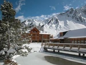 a ski lodge with snow covered mountains in the background at Appartement La Mongie, 3 pièces, 4 personnes - FR-1-404-200 in La Mongie