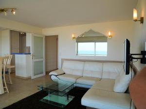 a living room with a white couch and a table at Quiberon: Appartement 3 pièces avec balcon et parking près du centre - FR-1-478-37 in Quiberon
