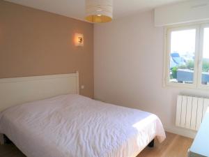 a bedroom with a white bed and a window at Quiberon: Appartement 3 pièces avec balcon et parking près du centre - FR-1-478-37 in Quiberon