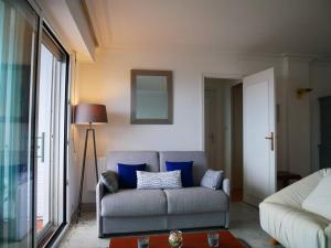 een woonkamer met een bank met blauwe kussens bij Studio Quiberon, 1 pièce, 3 personnes - FR-1-478-42 in Quiberon