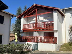 Casa bianca con balcone con ringhiera rossa di Appartement Cambo-les-Bains, 2 pièces, 2 personnes - FR-1-495-4 a Cambo-les-Bains