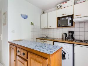 eine Küche mit weißen Schränken, einer Waschmaschine und einem Trockner in der Unterkunft Appartement Luz-Saint-Sauveur, 2 pièces, 4 personnes - FR-1-402-79 in Luz-Saint-Sauveur