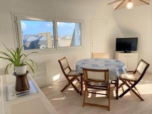 ein Esszimmer mit einem Tisch, Stühlen und einem TV in der Unterkunft Appartement Quiberon, 2 pièces, 3 personnes - FR-1-478-81 in Quiberon