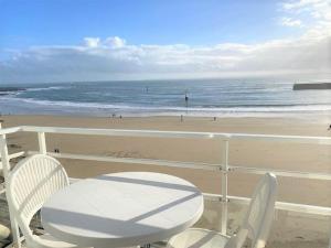 einen Tisch und Stühle auf einem Balkon mit Blick auf den Strand in der Unterkunft Appartement Quiberon, 2 pièces, 3 personnes - FR-1-478-81 in Quiberon