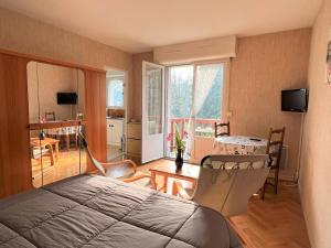 Un dormitorio con una cama y un comedor. en Charmant T1 Bis à Cambo-les-Bains avec balcon, ascenseur et parking - FR-1-495-31, en Cambo-les-Bains