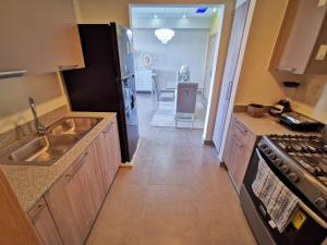 a kitchen with a sink and a refrigerator at 1br Luxury Condo Jacuzzigym Mountains with parking lot in Los Prados