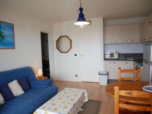 ein Wohnzimmer mit einem blauen Sofa und einem Tisch in der Unterkunft Appartement Étel, 2 pièces, 5 personnes - FR-1-479-37 in Étel