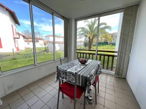 a table and chairs in a room with windows at Studio Cambo-les-Bains, 1 pièce, 2 personnes - FR-1-495-63 in Cambo-les-Bains