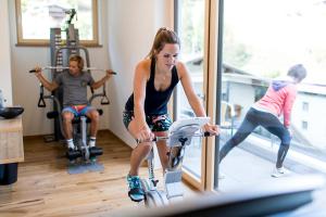 a woman riding an exercise bike in a gym at Ferienhaus & Apart Post in See