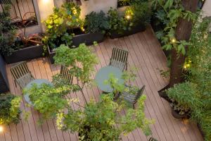 une terrasse avec une table, des chaises et des plantes dans l'établissement Hôtel La Canopée, à Paris