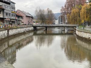 a bridge over a river in a city with buildings at Apartman MT in Kiseljak