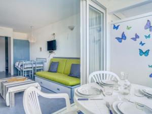 a living room with a table and butterflies on the wall at Appartement Urrugne, 2 pièces, 4 personnes - FR-1-4-567 in Urrugne