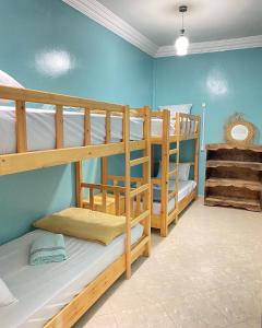 - 2 lits superposés dans un dortoir aux murs bleus dans l'établissement Imsouanegreenwave, à Imsouane