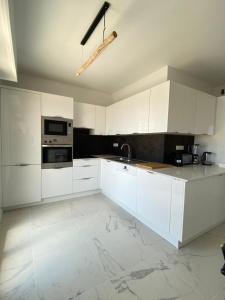 a white kitchen with white cabinets and appliances at T3 climatisé Villa Juana avec parking et proche plage in Antibes