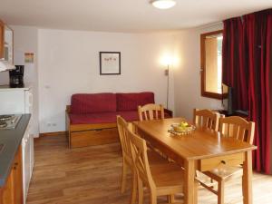 - un salon avec une table et un canapé rouge dans l'établissement Appartement Les Orres, 2 pièces, 6 personnes - FR-1-322-373, aux Orres