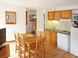 a kitchen and dining room with a wooden table and chairs at Charmant 2 pièces pour 6 avec piscine, jacuzzi et sauna - Les Orres - FR-1-322-373 in Les Orres