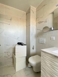 a white bathroom with a toilet and a sink at T3 climatisé Villa Juana avec parking et proche plage in Antibes