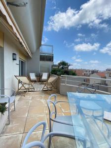 a patio with chairs and tables on a balcony at T3 climatisé Villa Juana avec parking et proche plage in Antibes