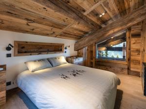 ein Schlafzimmer mit einem großen Bett in einem Zimmer mit Holzdecken in der Unterkunft Chalet luxe 5* pour 14 pers. à La Rosière avec hammam - FR-1-398-622 in Montvalezan