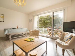 a living room with a table and a large window at Carnac Plage: Grand 3P avec Loggia, Wifi, Parking, proche commerces et plage - FR-1-477-30 in Carnac