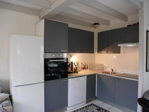 a kitchen with a white refrigerator and gray cabinets at Villa Capbreton, 3 pièces, 4 personnes - FR-1-413-79 in Capbreton