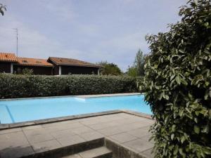 a swimming pool in front of a hedge at Villa Capbreton, 3 pièces, 4 personnes - FR-1-413-79 in Capbreton