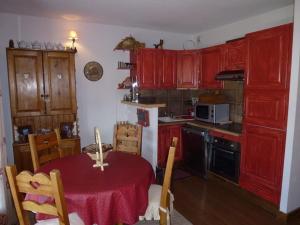 a kitchen with red cabinets and a table with a red table cloth at Charmant appartement 45m², 5 couchages, ski aux pieds, secteur chalets, Isola 2000 - FR-1-292-141 in Isola 2000