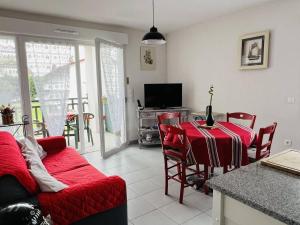 a living room with a red table and a couch at Charmant T2, centre Cambo, calme, Tt confort, terrasse, parking, proche commerces - FR-1-495-5 in Cambo-les-Bains