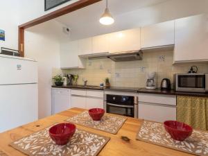 a kitchen with a wooden table with two red bowls on it at Appartement confortable 4 pers, 2 chambres, parking, proche centre Saint Lary - FR-1-296-278 in Saint-Lary-Soulan
