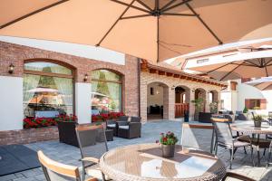 un patio extérieur avec des tables, des chaises et des parasols dans l'établissement Rezort Sivý Kameň, à Podhradie