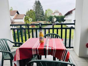 - une table rouge et blanche avec une boisson sur un balcon dans l'établissement Appartement Cambo-les-Bains, 2 pièces, 2 personnes - FR-1-495-5, à Cambo-les-Bains