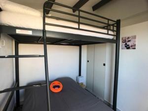 une chambre avec deux lits superposés et un objet orange dessus dans l'établissement Villa T2, 4 pers, face à la mer, terrasse, parking privé, à 400m des commerces, plage devant! - FR-1-81-462, à Port-Leucate