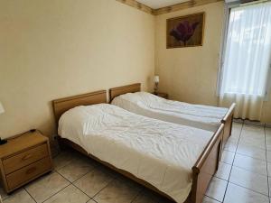 two beds in a small bedroom with a window at Appartement Cambo-les-Bains, 3 pièces, 4 personnes - FR-1-495-18 in Cambo-les-Bains