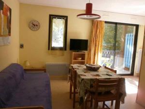 een woonkamer met een tafel en een blauwe bank bij Appartement Saint-Lary-Soulan, 2 pièces, 6 personnes - FR-1-457-230 in Saint-Lary-Soulan
