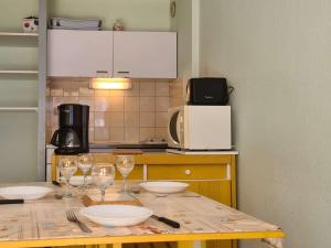 a kitchen with a table with wine glasses on it at Appartement Saint-Lary-Soulan, 2 pièces, 6 personnes - FR-1-457-253 in Saint-Lary-Soulan