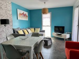 Sala de estar azul con mesa y sofá en Appartement Itxassou, 2 pièces, 3 personnes - FR-1-495-47, en Itxassou