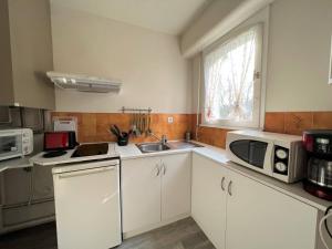 a small kitchen with a sink and a microwave at Appartement Cambo-les-Bains, 1 pièce, 2 personnes - FR-1-495-50 in Cambo-les-Bains